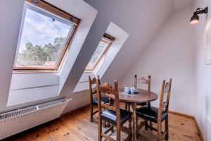 a dining room with a table and chairs and a window at Hotel Jelita in Nida