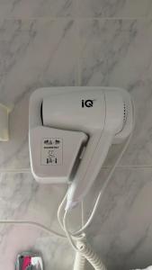 a white hair dryer on the wall of a bathroom at Hotel Cosmos in Athens