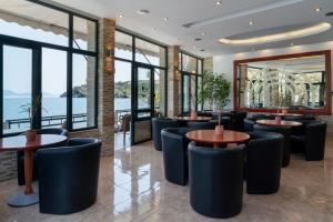 a restaurant with tables and chairs and a view of the ocean at Binji Hotel in Ancient Epidauros