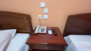 a phone sitting on a table between two beds at Hotel Cosmos in Athens
