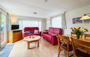 a living room with red furniture and a table at Amazing Home In Tzummarum With Outdoor Swimming Pool in Tzummarum