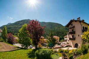 - une vue sur un village avec une maison et des montagnes dans l'établissement Hotel Carlone, à Breguzzo