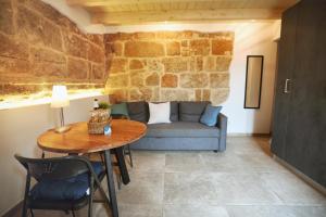 a living room with a table and a couch at Domo del Convento in Alghero