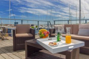 a table and chairs on a deck on a boat at Hausboot - Stina in Heiligenhafen