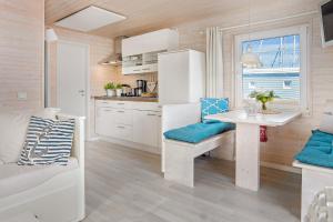a kitchen and dining room with a table and a window at Hausboot - Stina in Heiligenhafen +12 photos