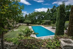 einen Pool in einem Garten mit Bäumen in der Unterkunft Propriété d'exception au coeur du Luberon in Robion en Luberon