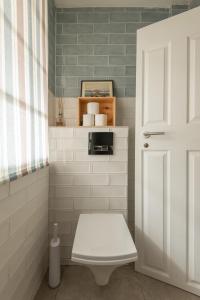 een badkamer met een toilet en een witte deur bij 99 Steps to the Sea in Brighton & Hove
