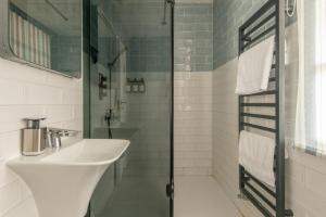 a bathroom with a sink and a glass shower at 99 Steps to the Sea in Brighton & Hove