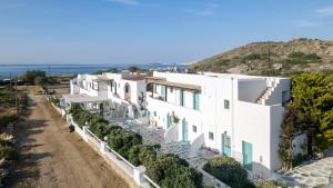 a row of white houses with the ocean in the background at Naxos Cave Suites in Stelida