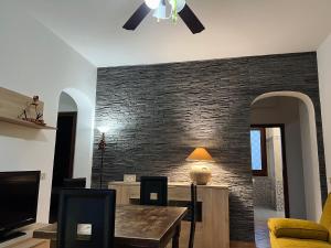 a living room with a brick wall and a table at Villa con piscina TERRAZZA DAL PICCIOTTO in Marsala