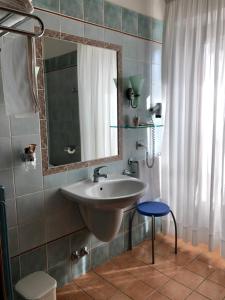 a bathroom with a sink and a mirror and a stool at Hotel Zodiaco in Bolsena