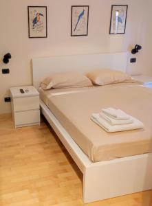 - un lit blanc dans une chambre avec une table de nuit dans l'établissement 6 a casa, à Milan
