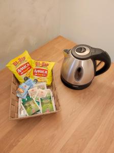 una cesta de comida y un hervidor de agua sobre una mesa en 6 a casa en Milán