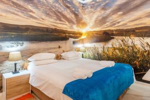1 dormitorio con 1 cama y vistas al río en Daddy Long Legs Art Hotel, en Ciudad del Cabo