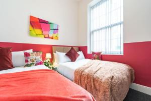 two beds in a room with red walls at Jesouth Gorgeous Inn Striking Splashy Flashy Wifi in Hull
