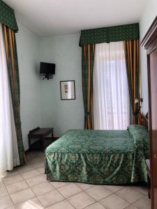 a bedroom with a green bed and a window at Hotel Zodiaco in Bolsena