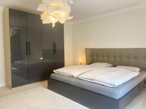 a bedroom with a bed and a chandelier at Ruhiges Landhaus am Wald mit Garten mit Schlafzimmer und Schlafnische in Aurich