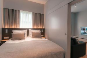 a bedroom with a large bed and a chair at Original Sokos Hotel Seurahuone Savonlinna in Savonlinna