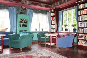 a library with chairs and a table and books at Haus Antje in Ahrenshoop
