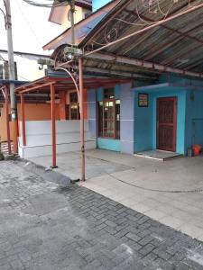 un edificio azul y blanco con una puerta roja en Villa Bukit Asri Untuk 1 Kamar Berastagi View, en Berastagi