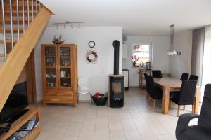 Blaue Möwe في نوردين: غرفة معيشة مع موقد خشبي وطاولة