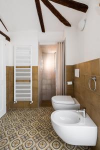 a bathroom with two toilets and a sink at Appartamento San Martino by Wonderful Italy in Bologna