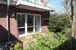 a brick house with a window and a balcony at Frida in Norddeich