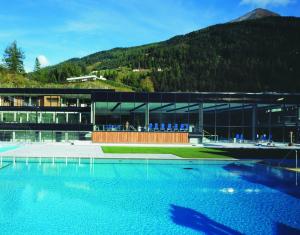 un grande edificio con una grande piscina d'acqua di Hotel Wetzlgut a Bad Gastein