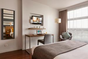 Una habitación de hotel con una cama y un escritorio con una computadora portátil. en Citadines City Centre Lille, en Lille