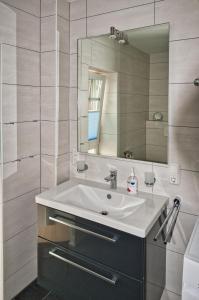 a bathroom with a sink and a mirror at GrachtenGlück in Greetsiel