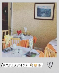 a table with two chairs and a table with cups and plates at Donnybrook Hall in Dublin