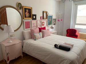a bedroom with a large white bed with a mirror at Casa Seines in León