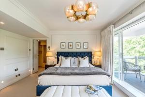 a bedroom with a large bed and a chandelier at Buckingham & Lloyds in London