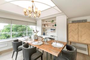 a dining room with a table and chairs and a chandelier at Buckingham & Lloyds in London