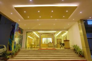 un vestíbulo con una escalera en un edificio en Regenta Orkos Kolkata by Royal Orchid Hotels Limited en Calcuta