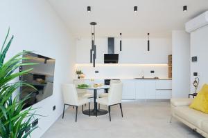 eine Küche und ein Wohnzimmer mit einem Tisch und Stühlen in der Unterkunft Hedera Estate, Hedera A28 in Dubrovnik