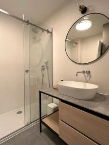 y baño con lavabo y ducha con espejo. en Stiva Apartment - new apartment with free parking, 150m from the beach, en Kaštela