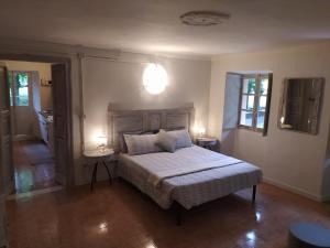 a bedroom with a bed with two tables and two lamps at Agriturismo Podere Luciano in Acqui Terme