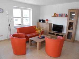- un salon avec un canapé orange et une table dans l'établissement Norderland, à Norddeich