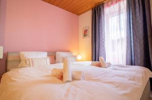 a bedroom with a bed with white sheets and a window at Haus Padrun, Apartment nr.6 in Arosa