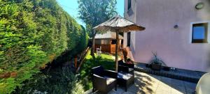 obraz domu z krzesłami i parasolem w obiekcie Pool Apartments w Karlowych Warach
