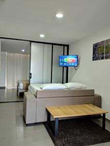 a bedroom with a bed and a tv on a wall at Berilo Deluxe Apartahotel in Barranquilla