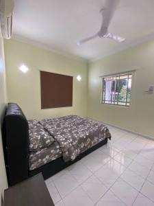 a bedroom with a bed and a flat screen tv at Room/Homestay NazaDja in Sungai Besar