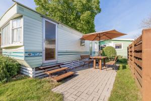 a house with a patio with a table and an umbrella at Atokaita in Palanga