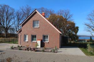 a red brick house with a driveway in front at Ruth in Warin