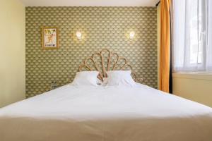 a large white bed with two pillows on it at Hôtel Cosmopolitain in Biarritz