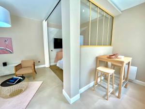 uma sala de estar com uma mesa e uma cadeira em Suite Monceau - Reims em Reims