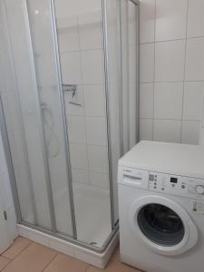 una lavatrice in un bagno con doccia di Strandgut a Norddeich