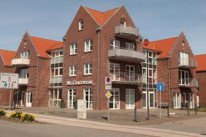 un grande edificio in mattoni rossi con balcone su una strada di Strandgut a Norddeich