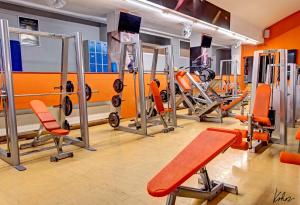 une salle de sport avec des chaises oranges et des tapis de course dans l'établissement AXA Hotel, à Prague